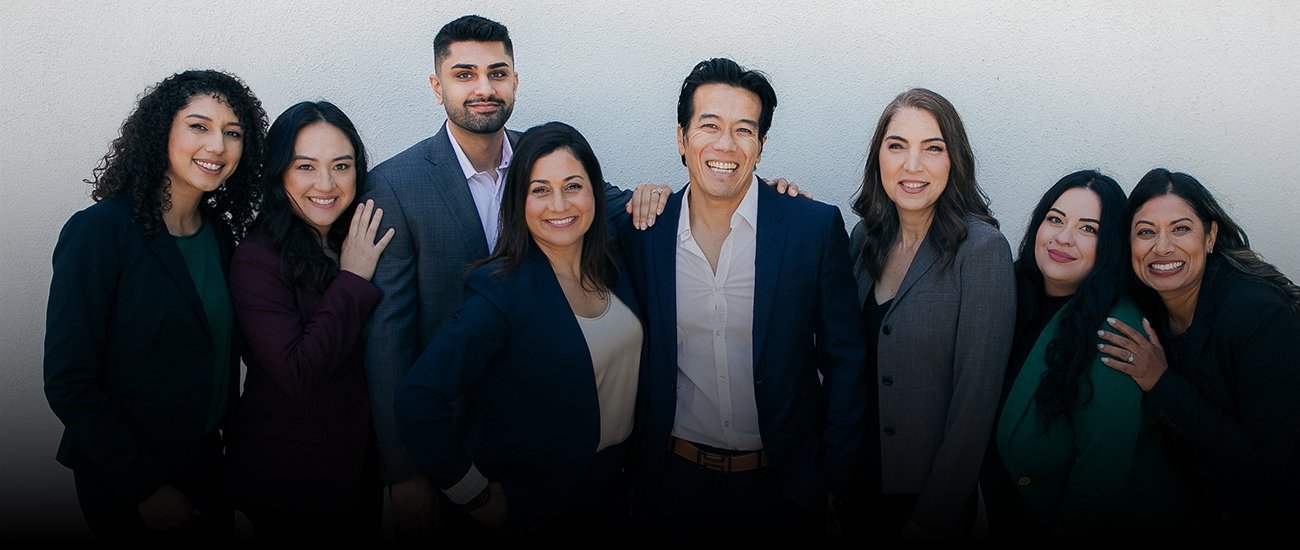 The eight people of Phancao & Shaffer, LLP, photographed together against a light wall.